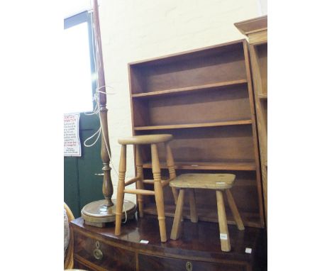 A pair of wicker elbow chairs, standard lamp, two stools and an open bookcase