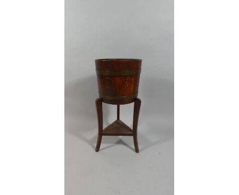 An Edwardian Brass Banded Oak Planter on Tripod Support. 69cms High. RA Lister and Co