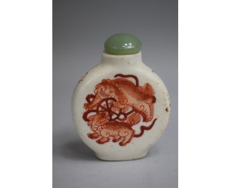 A Chinese Ceramic Snuff Bottle of Flattened Circular Form, decorated with Orange Enamelled Scenes of Foo Dogs amongst Scrolls