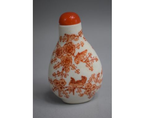 A Chinese Ceramic Snuff Bottle of Pear Shape decorated with Orange Enamels depicting Birds in Foliage Complete with Stopper (