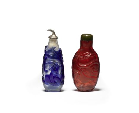 TWO GLASS 'CHILONG' SNUFF BOTTLES18th/19th centuryThe first of sapphire-blue overlay translucent glass, carved on each side w