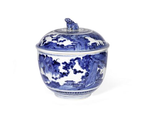 A LARGE ARITA BLUE AND WHITE DEEP BOWL AND COVERCirca 1700With seated karashishi finial, decorated with pavilions nestling am