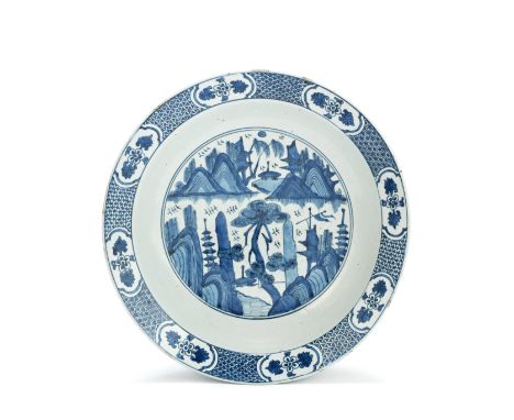 A BLUE AND WHITE DEEP DISHLate Ming DynastyPainted with a central medallion of pagodas amidst craggy mountains, all centred a