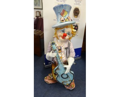 A large ceramic child clown playing guitar, height 3ft.