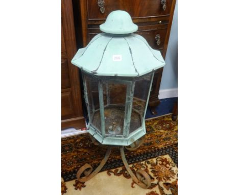 An antique copper lantern originally fitted for gas on a wrought iron stand, height 85cm.