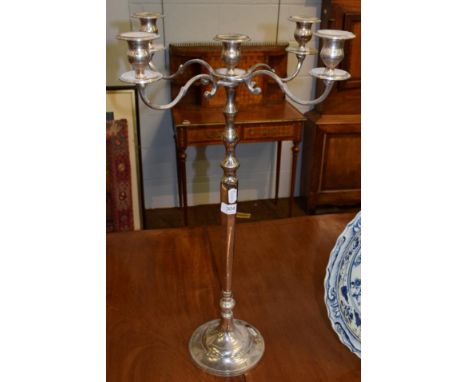 A large slender decorative five light silver plated candelabra, the four scroll cast arms issuing from a triple baluster and 