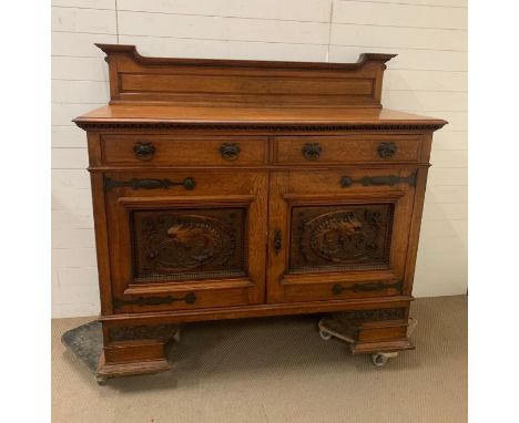 A Side cabinet with raised back, two drawers over a pair of carved doors on bracket feet. To the side is a hinged door openin