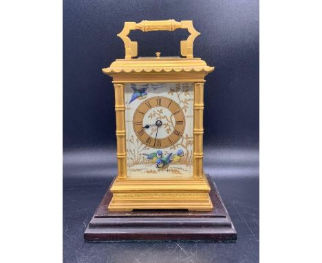 A Late 19th Century French gilt-brass and painted porcelain carriage clock (H 17cm) On a wooden plinth.