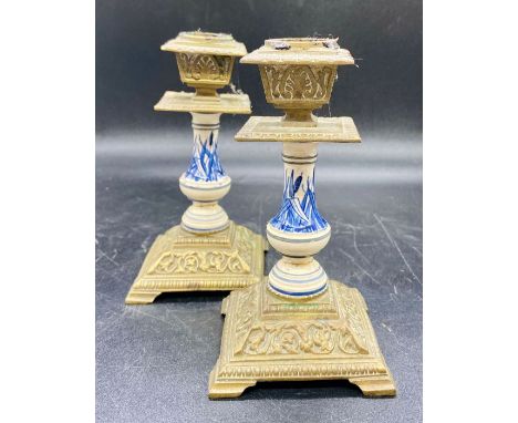A pair of Delt and brass candlestick holders on square bases and bracket feet 