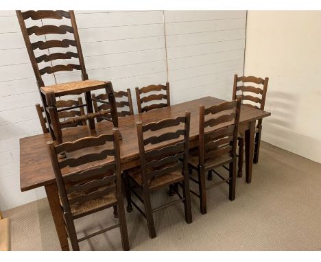 An oak French farmhouse table with eight ladder back high seats (H77cm W210cm D90cm)