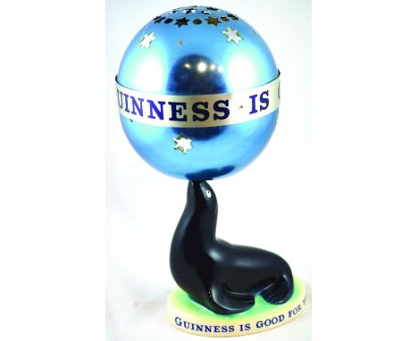 GUINNESS SEAL LAMP. 15ins tall to top of revolving metal shade. Ceramic seal base mainly black on green & white base GUINNESS