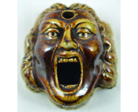 BELLOWING MAN INKWELL. 3ins long, variating tan &amp; brown salt glaze in shape of a bewigged mans face with gaping mouth ink