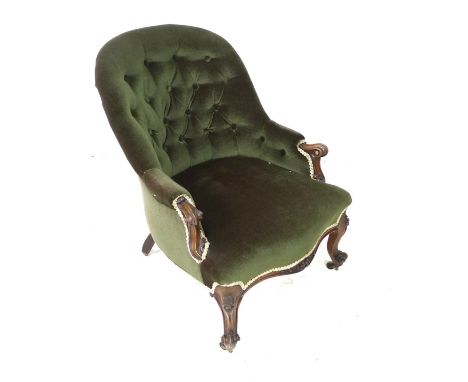 A Victorian spoon back armchair, with green button back upholstery, raised upon mahogany cabriole scroll feet and castors, 60
