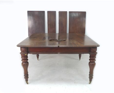 An early Victorian mahogany extending dining table, with four additional leaves, turned legs and white ceramic castors, winde