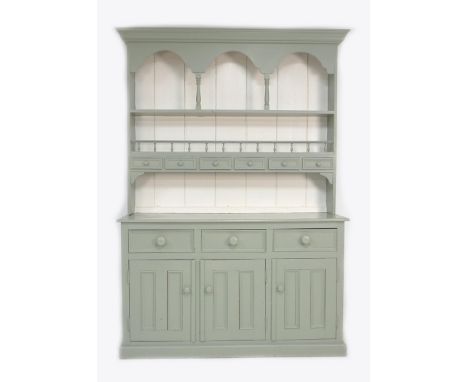 A modern painted pine dresser, sage green and white, the plate rack fitted with six spice drawers and arched decoration, the 