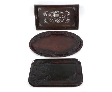 A group of three Oriental hardwood trays, comprising a Chinese tray with inlaid mother of pearl decoration depicting clouds, 
