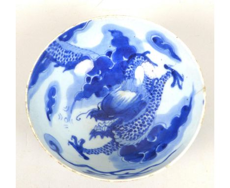 A Chinese Qing Dynasty, early 18th century, porcelain bowl, decorated in underglaze blue with a dragon chasing a flaming pear