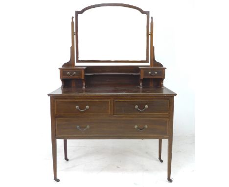 An Edwardian mahogany dressing table, with arched rectangular mirror, trinket drawers, over two short and one long drawer, 10