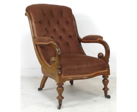 A Victorian button backed mahogany framed open armchair, with brown velvet upholstered seat, back and armrests, turned fore l