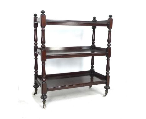 A William IV / early Victorian mahogany three tier buffet server, with turned supports, raised upon white ceramic castors, 99