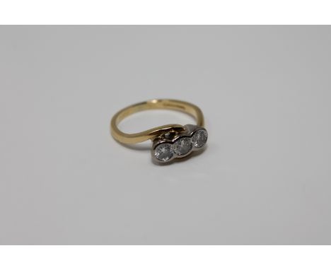 An 18ct gold three stone diamond twist ring, size K 