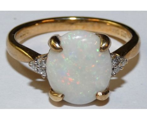 A 9ct gold opal and diamond dress ring, the cabochon cut stone with single cut diamond trefoils shoulders, size N.