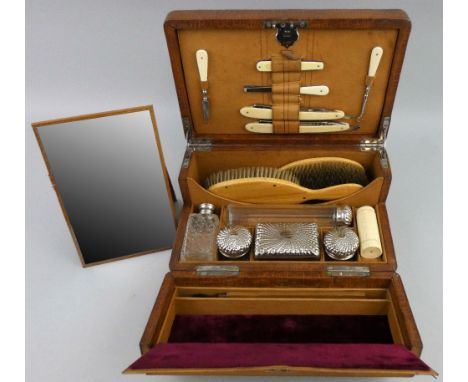 A late Victorian gent's travelling toilet set with reptile skin leather cover, of rounded oblong form, the hinged lid with re