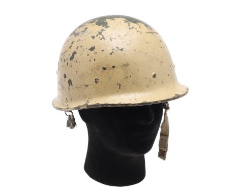 AN IRAQI DESERT STORM COMBAT HELMET. An Iraqi helmet with worn sand coloured painted shell, internally with worn liner and re