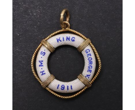 AN ENAMEL BROOCH COMMEMORATING THE LAYING DOWN OF THE KEEL FOR H.M.S. KING GEORGE V. An unmarked gilt metal and enamel pendan