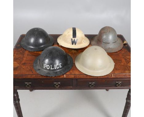 A COLLECTION OF SECOND WORLD WAR HOME FRONT HELMETS. An interesting collection of five helmets, a black composition helmet wi