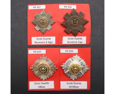 A SILVER OFFICER'S SCOTS GUARDS CAP BADGE AND THREE OTHERS. A Scots Guards Officers cap badge with a thistle against green en