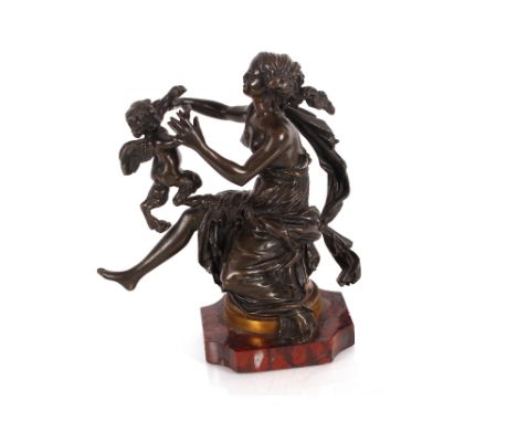 An antique bronze figure depicting a partially naked maiden and cherub, 18cm high