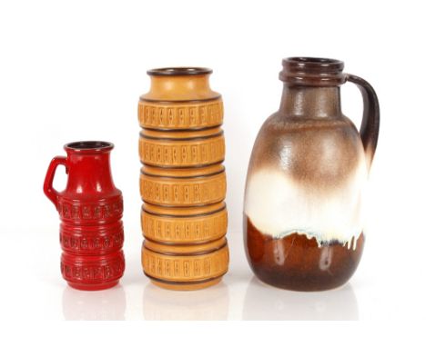 A West German glazed pottery pitcher; a smaller red glazed example; and a West German pottery baluster vase 