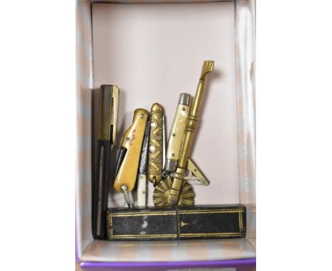A selection of vintage pen knives, including one with bone handle, cork screw and an antique pastry jigger.