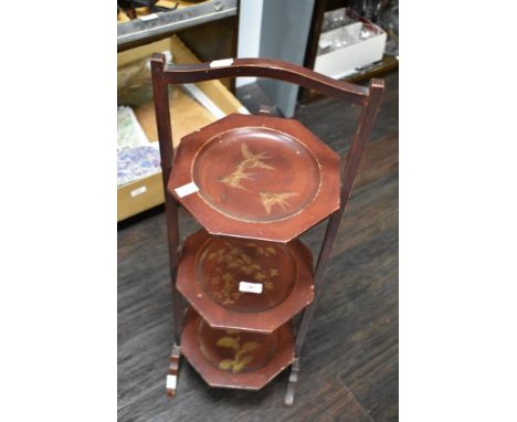 A vintage three tiered wooden cake stand, having gilt painted scenes to each tier.