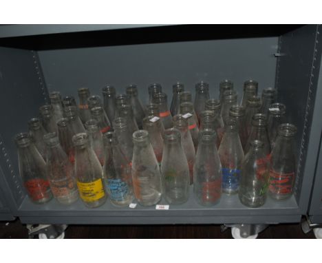 A large quantity of vintage glass milk bottles, with advertising, including 'S.Anderton &amp; Son of Scorton', 'E.Coultherd o
