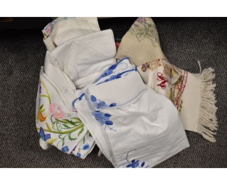 A selection of vintage table linen, including intricately embroidered items, crochet edged examples and crinoline lady table 