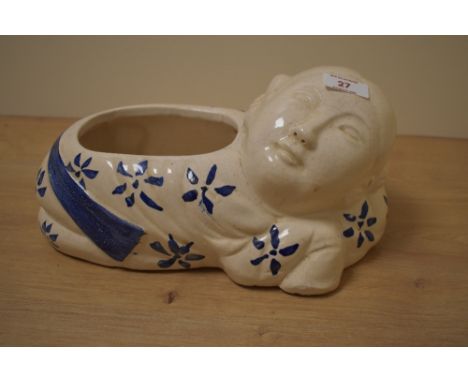 A 20th Century glazed pottery blue and white planter, in the form of a reclining figure, and stamped 'Hong Kong 5307' to the 