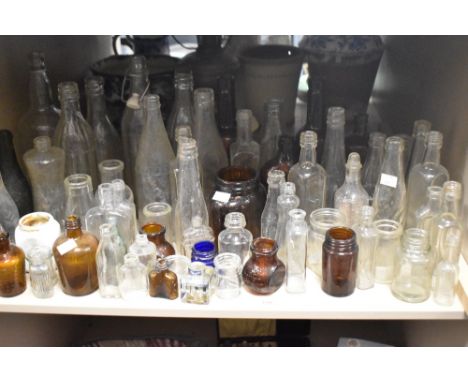 A large collection of vintage glass bottles and jars , including advertising bottles of interest to Dumfries, medicine bottle