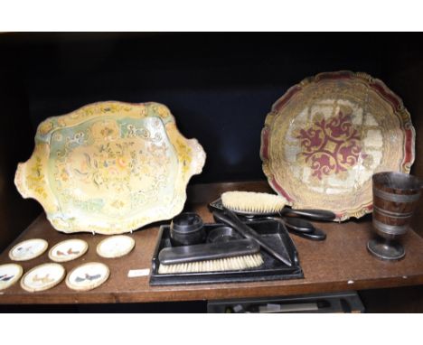 Two vintage wooden trays, one having red and gold motifs and the other with foliate decoration, an ebony dressing table set, 