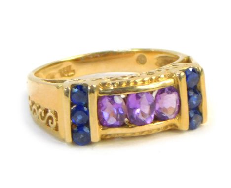 A dress ring, formed with three amethysts in tension setting, with six tiny sapphire set shoulders, with raised and pierced s