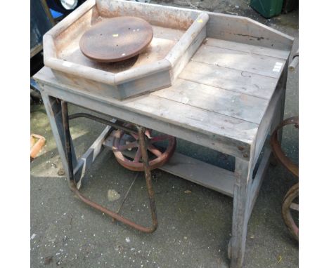 A manual potter's wheel turning table, with wooden framed top, cast iron spring base, 100cm high, 93cm wide, 51cm deep.