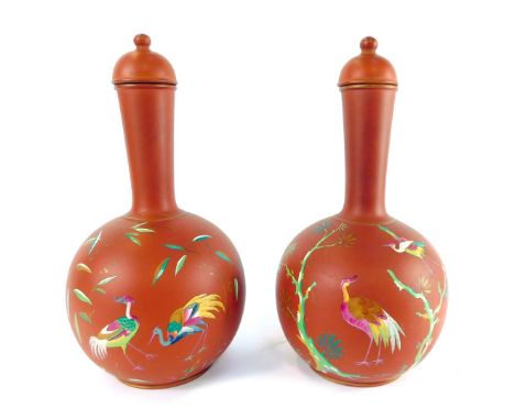 A pair of late 19thC terracotta bottles and lids, enamel decorated with exotic birds, number 9987, 30cm high. 