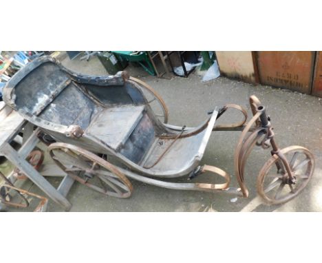 A vintage wooden bath chair, with shaped seat, on three wheeled supports, leather straps, bound metalwork, 131cm high, 180cm 