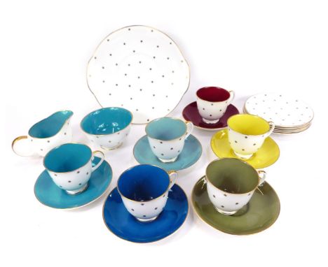 A Susie Cooper porcelain pert part service, decorated with gold stars, comprising six harlequin coloured tea cups and saucers