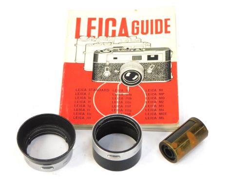 A Leica Reloadable cassette, 50mm lens hood, and a Leica guide book. (3)