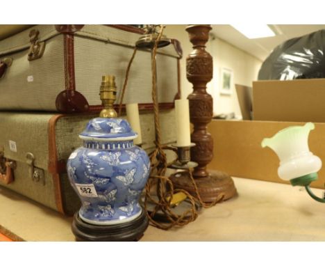 A carved wooden lamp, a lamp made from a blue and white lidded vase and a silver plated twin candle lamp converted to electri