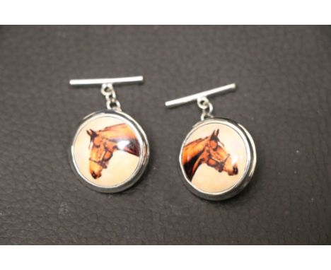 A pair of silver and enamel set cufflinks depicting horses