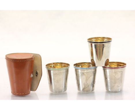 Set of Four Stacking Stirrup Cups, each with different coloured Enamel Band and Gilt Interiors, all contained in a Leather Ca