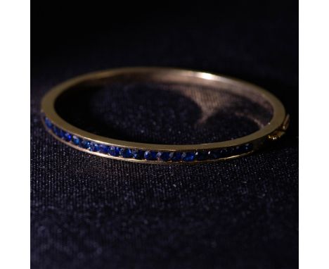 Stunning bangle bracelet in 18K gold with 1.50ct blue sapphires. Measures 2.25" x 2" inside when closed. Weight 20.44 grams. 